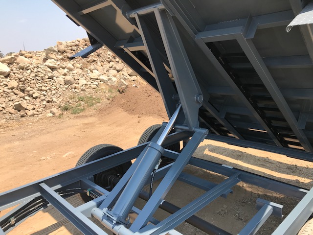 The Iron Panther dump trailer raised with a close look at the industry-grade scissor lift