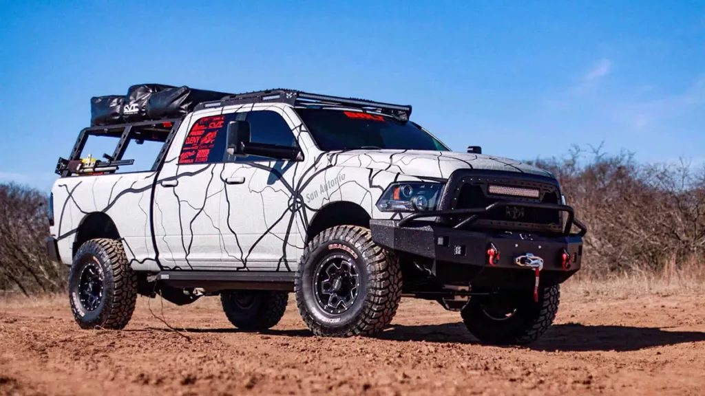 A white truck equipped with a HammerHead Armor Frontier Series front bumper rides through a desert.