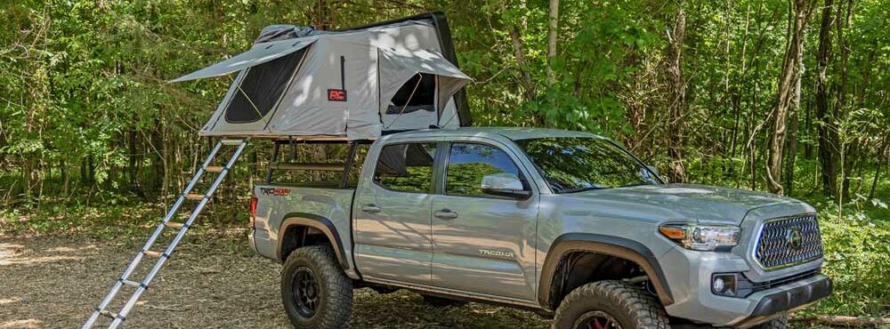 Rough Country Hard Shell rack-mounted tent mounted and opened on a grey Toyota Tacoma.