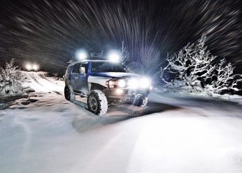 Off-road Vehicle On Snow Covered Field At Night with bright LED lights