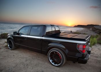 pickup truck parked on beach equipped with folding tonneau cover